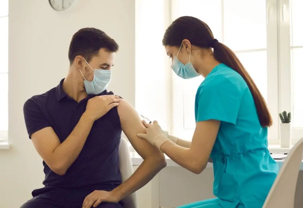 Nurse administering vaccine during home visit in Dubai